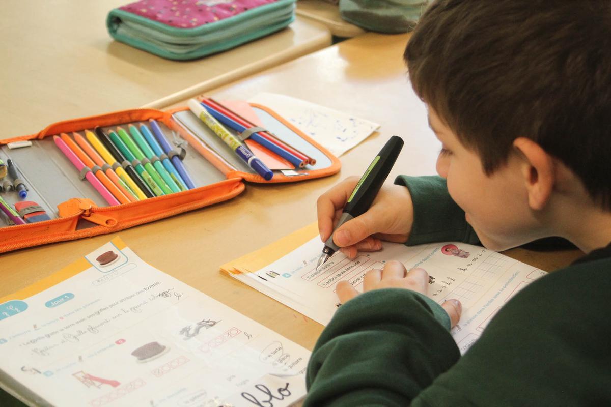 Un élève de primaire en train de faire un exercice de francais