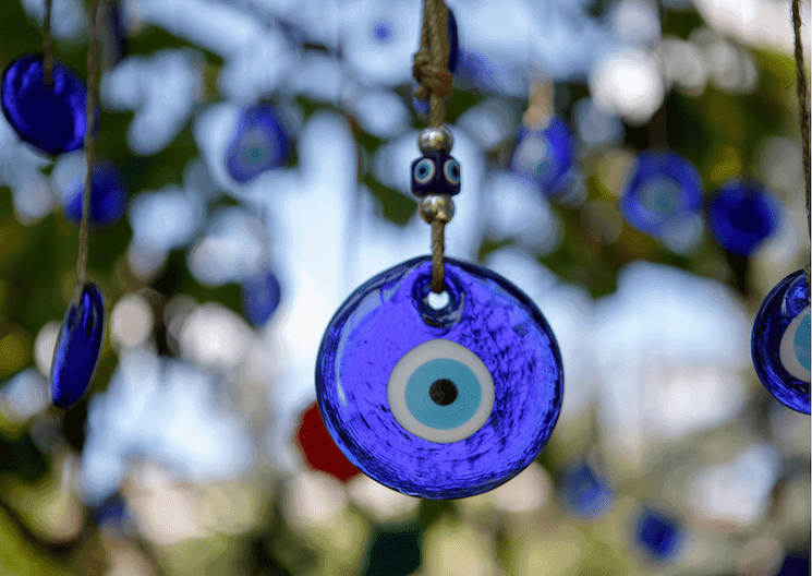 Gros plan sur un nazar, l’œil bleu protecteur, suspendu dans les ruelles de Nazarköy près d’Izmir.