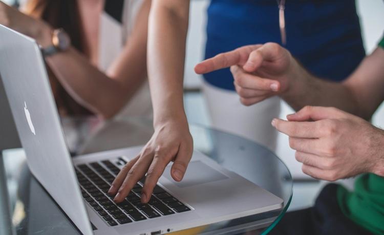 personnes pointent écran d'un macbook