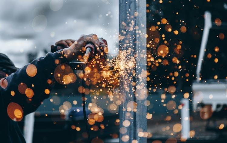 un homme tient un outil qui fait des étiencelles