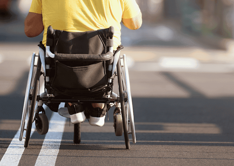 Personne en fauteuil roulant avançant sur une voie urbaine, symbole des enjeux d’accessibilité en Turquie.
