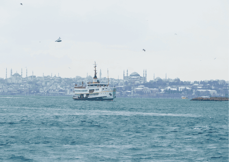 Ferry sur le Bosphore avec la péninsule historique enneigée en arrière-plan, hiver à Istanbul