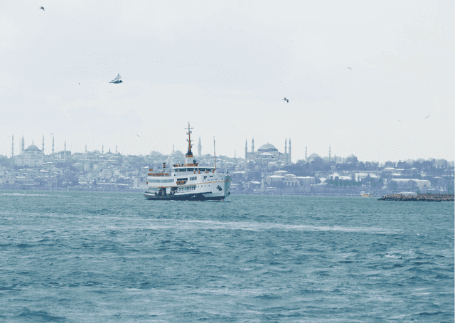 Ferry sur le Bosphore avec la péninsule historique enneigée en arrière-plan, hiver à Istanbul