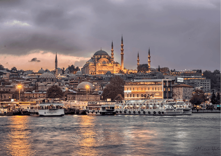 Vue de la mosquée Süleymaniye au crépuscule depuis la Corne d’Or, silhouette d’Istanbul et ferries sur le Bosphore.