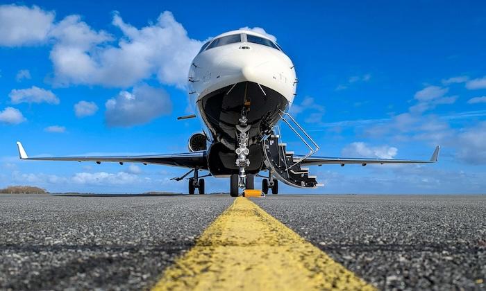 un jet de luxe sur une piste de décollage et le ciel bleu