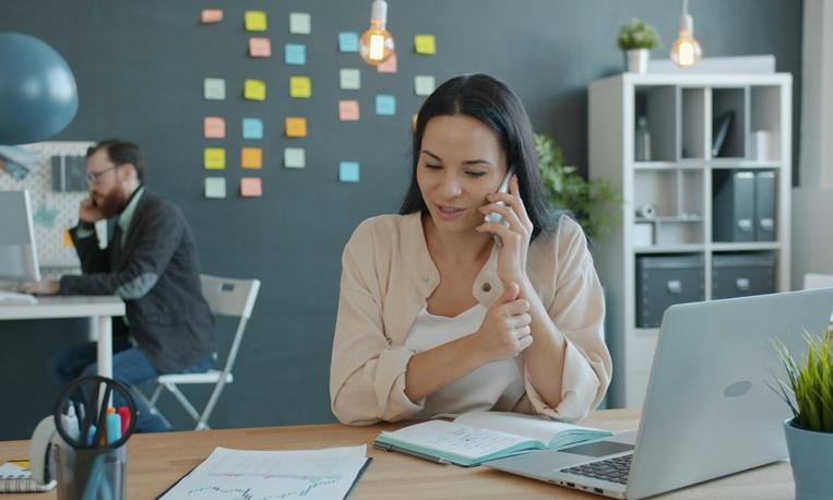 une femme au téléphone devant son ordinateur