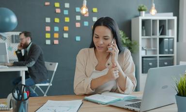 une femme au téléphone devant son ordinateur