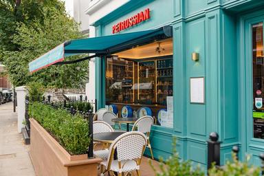 Devanture d'une épicerie avec des chaises sur une terrasse en bois