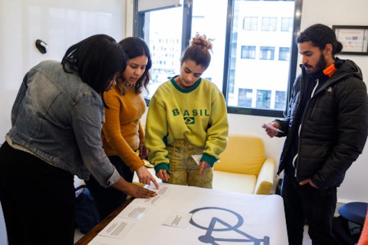 des jeunes personnes regardent un texte dans une salle