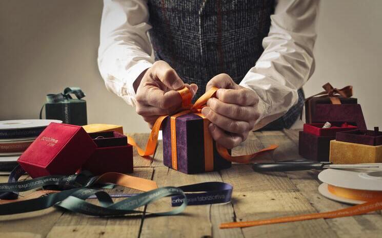 Un homme en train de faire des paquets cadeaux