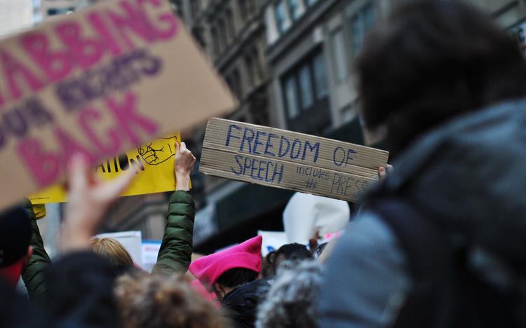 Des personnes tiennent des pancartes lors d'une manifestion pour la liberté d'expression et de la presse.