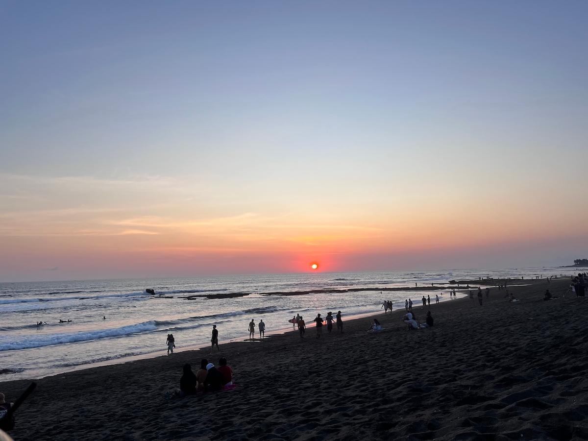 plage de batu balong à bali avec coucher de soleil et touristes