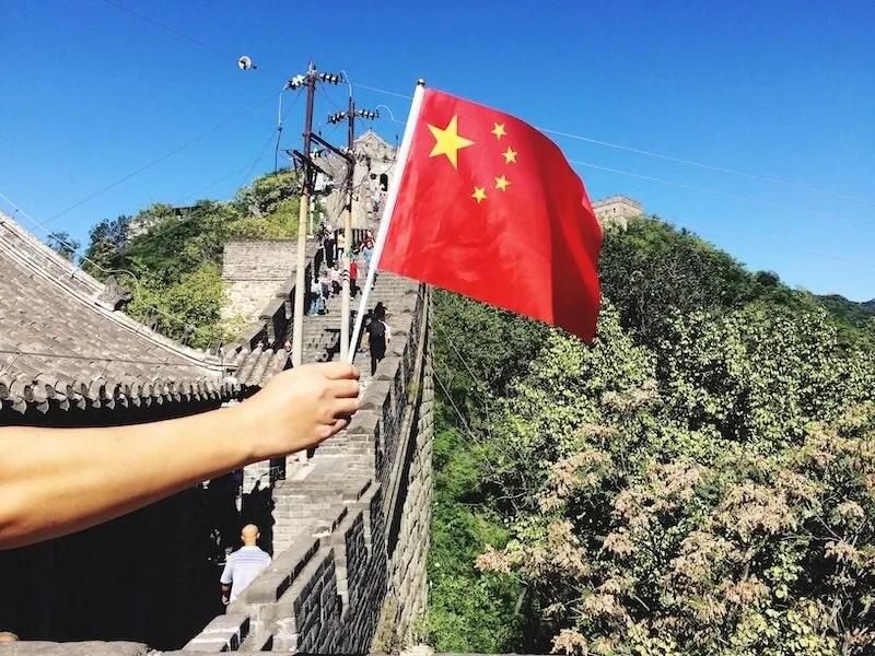 hand-holding-flag-of-china-in-the-great-wall-of-ch-2021-08-30-09-37-12-utc.jpg