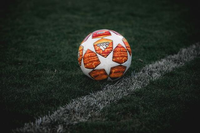 Ballon de foot à l'envers posé sur une pelouse