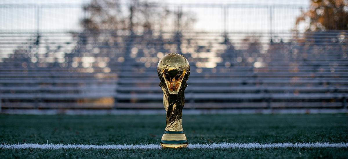 Photo de la Coupe du monde de football posée sur un terrain de football
