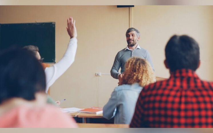 élève qui lève la main lors d'un cours