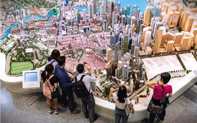 Des visiteurs devant la maquette de Singapour dans les locaux de Urban Redevelopement Authority.