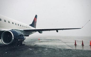 Photo d'un avion sur une piste d'aéroport alors qu'il neige