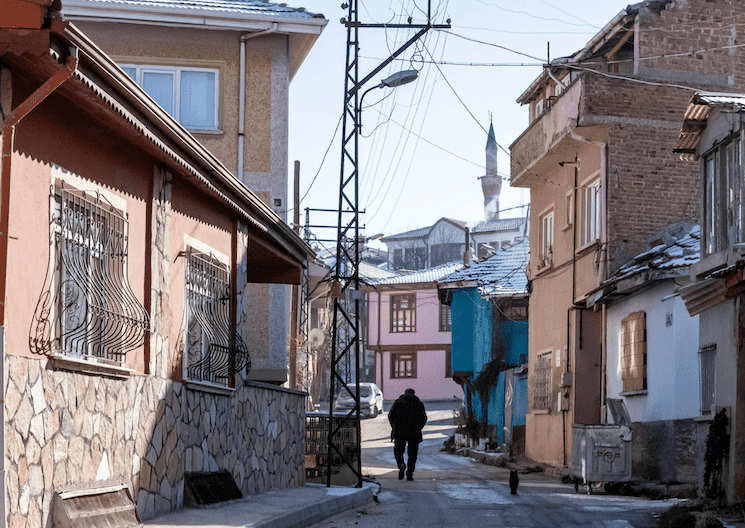 Rue résidentielle en Turquie avec un homme marchant, scène du quotidien illustrant la société turque