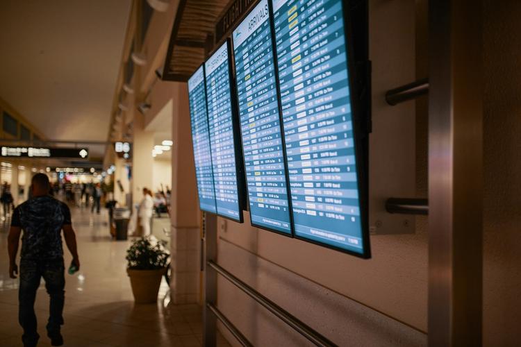 écran départs aéroport avec un voyageur