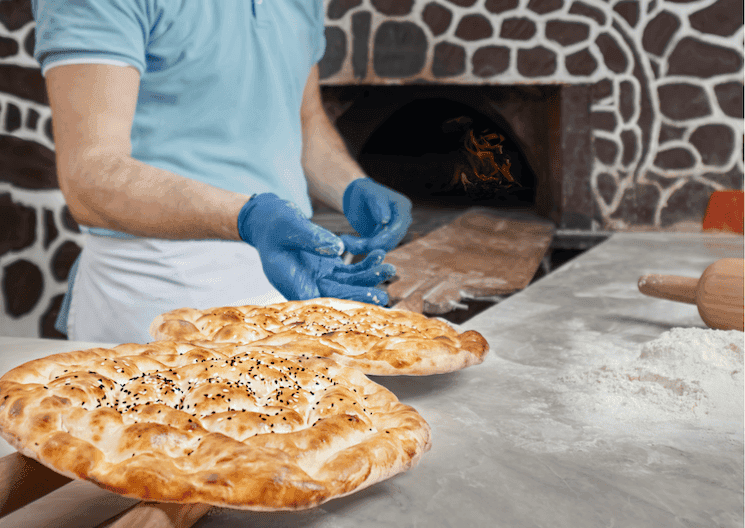 Boulanger préparant des ramazan pidesi dans un four traditionnel à Istanbul avant l’iftar du Ramadan