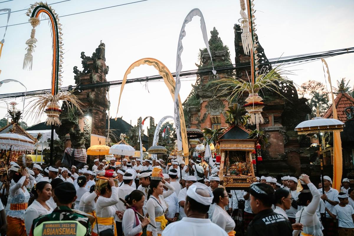 des balinais en blanc pendant une cérémonie devant un temple
