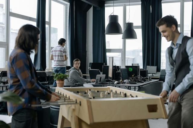 Un bureau moderne avec des équipes en interaction autour d'un baby foot
