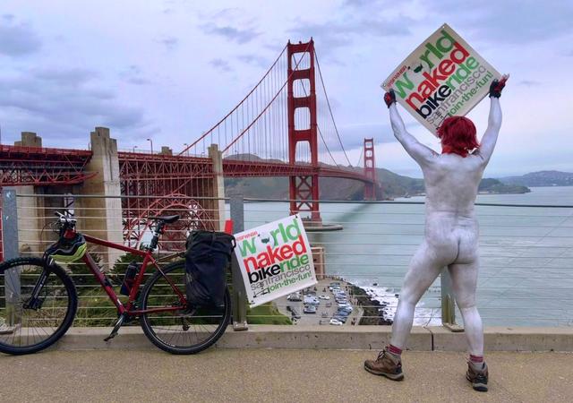 Un homme avec le corps peint avec son vélo devant la Golden Gate Bridge à San Francisco pour la World Naked Bike Ride