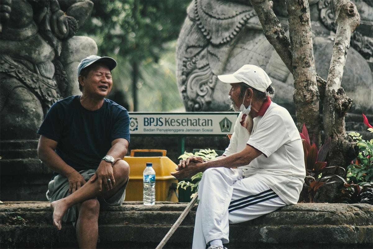 deux hommes qui parlent à bali devant un temple