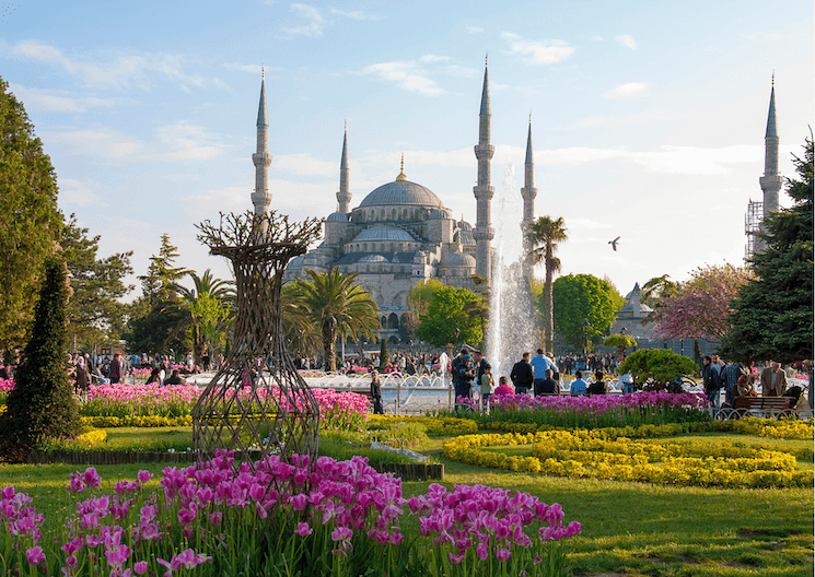 Istanbul au printemps 2026, parc fleuri avec tulipes devant la Mosquée Bleue et visiteurs profitant des sorties culturelles en plein air