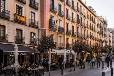 Rue animée bordée d’immeubles à balcons avec terrasses de cafés, illustrant la vie en appartement et la sociabilité urbaine en Espagne.