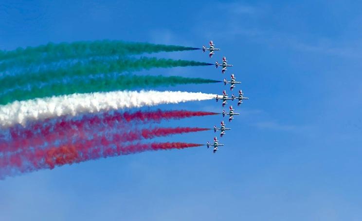 des avions trainent une fumée colorée dans un ciel bleu