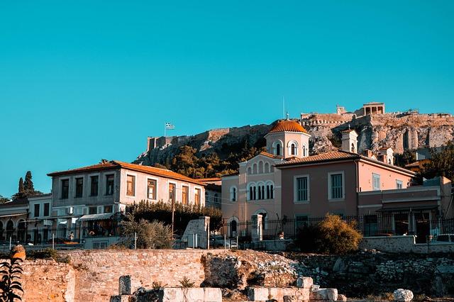 Vue en contre-plongée de l'Acropole, une maison d'époque et une église étant visible au premier plan