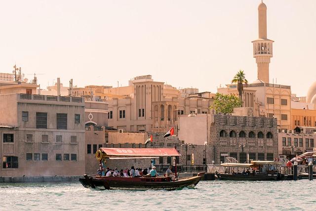 Une ville côtière du Moyen-Orient prise depuis la mer, un petit bateau passant devant l'objectif.