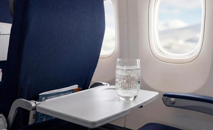 Un verre de boisson gazeuse sur une tablette dans un avion