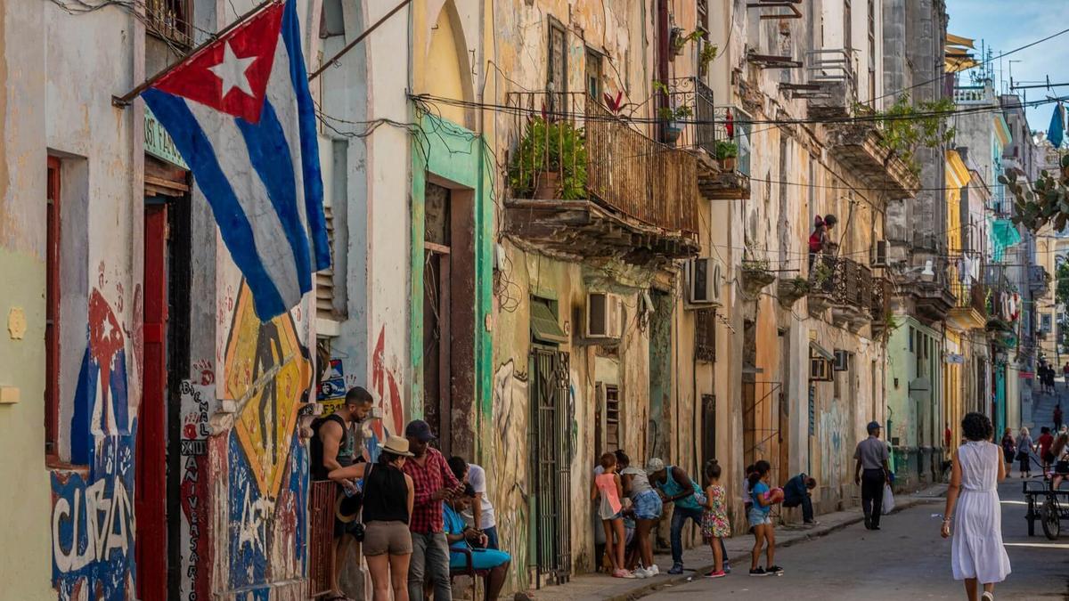 Photo d'une rue de La Havane à Cuba, avec en premier plan de drapeau cubain