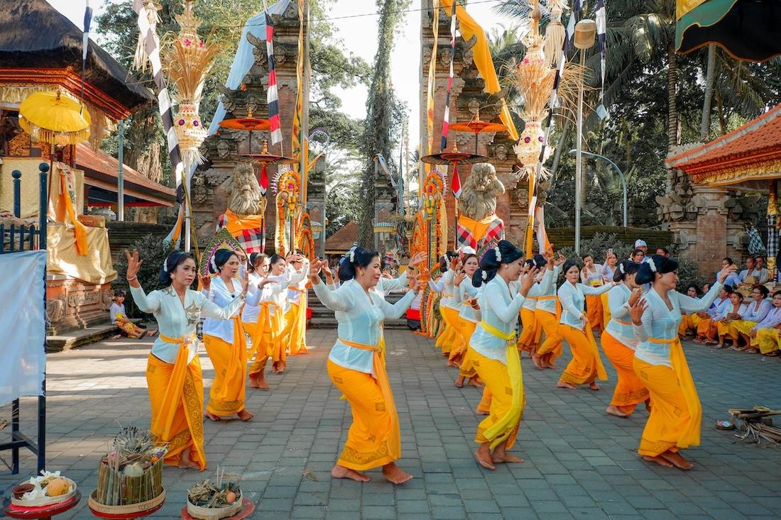 des femmes balinaises en tenue traditionnelle avec un sarong jaune qui dansent