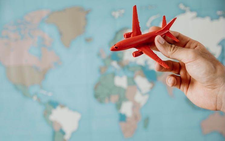 side-view-person-holding-airplane-figurine-map