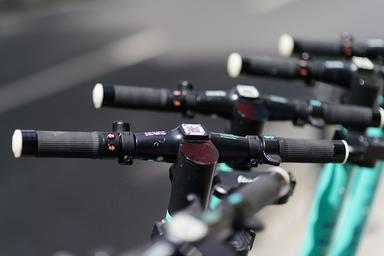 Zoom sur des guidons de trottinette électriques dans une rue