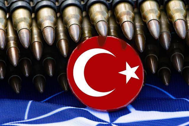 Vue d'une cocarde turque posée sur un drapeau de l'OTAN, des munitions étant visibles à l'arrière plan de l'image