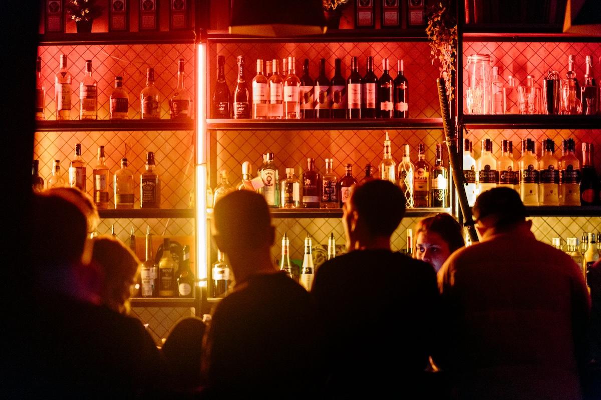 des hommes de dos dans un bar