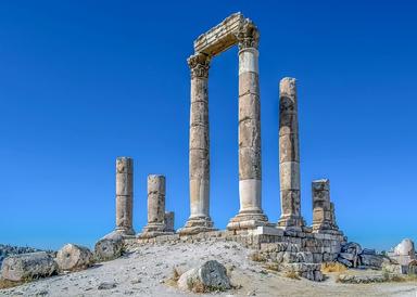 Vue des ruines d'un temple antique sur une colline de même couleur, seul le ciel bleu étant visible en arrière-plan