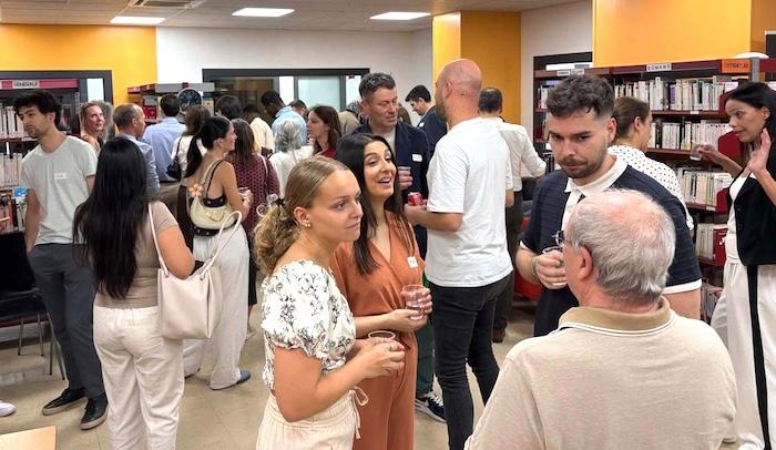 des personnes échanger, discuter, réseauter, verre à la main ou autour de stands du salon emploi en espagne.