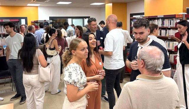 des personnes échanger, discuter, réseauter, verre à la main ou autour de stands du salon emploi en espagne.
