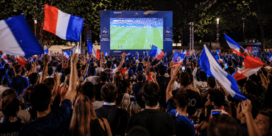 Des supporters français réunis devant un écran géant en plein air pour suivre la demi-finale France - Espagne de la Coupe du Monde dans une ambiance festive.