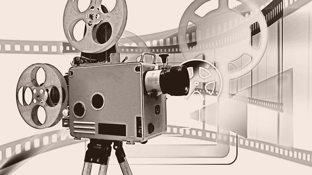 Vue d'une caméra de film sur fond blanc, une bobine étant visible sur ce fond