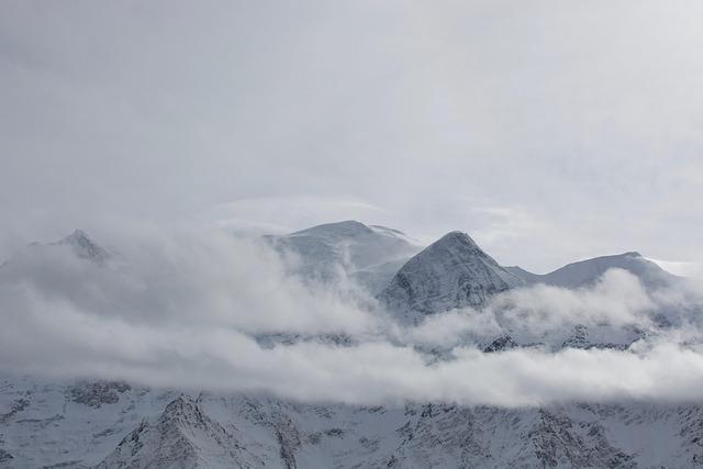 Vue du mont Olympe enneigé depuis un hélicoptère, la brume cachant une partie de la montagne