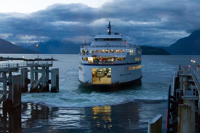 Un ferry arrivant au port par une soirée orageuse, la photo étant prise depuis le quai d'amarrage
