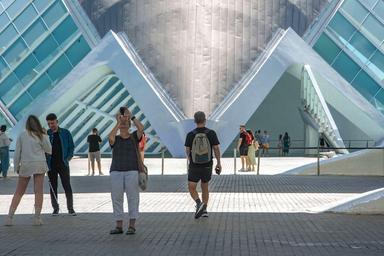 une femme en train de prendre une photo et des touristes devant la cité des arts et des sciences à valencia en espagne