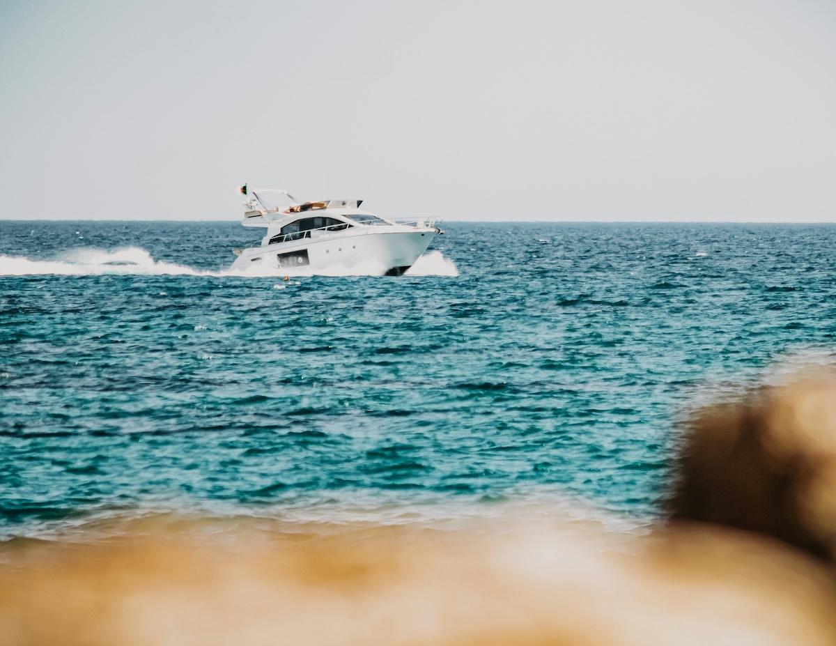 un bateau sur la mer avec un rocher au premier plan
